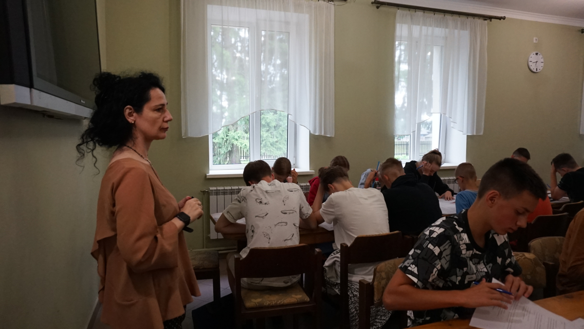 Letnia Szkoła Języka Polskiego na Ukrainie – kilkanaście osób siedzących przy stolikach w dużej sali